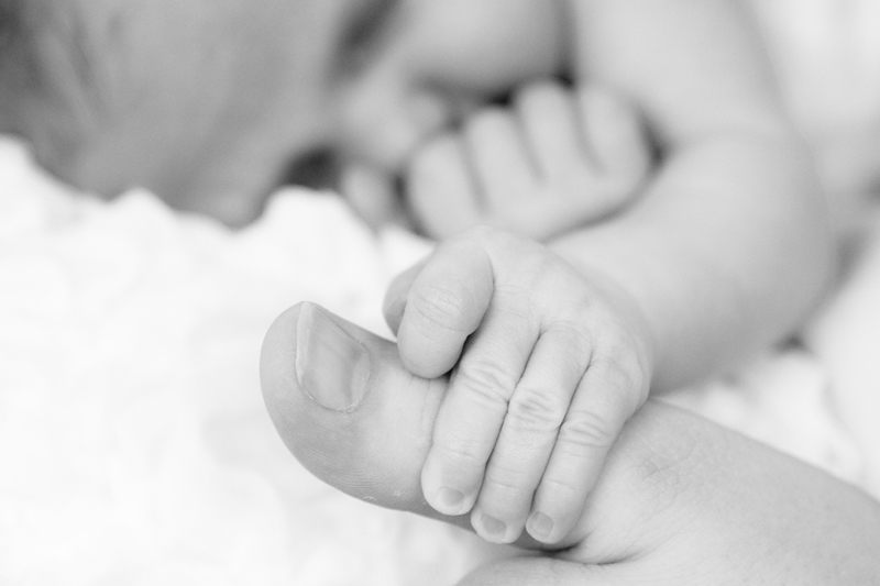 Newborn fotografie handje om duim